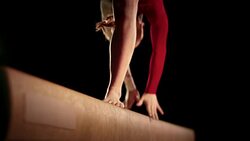 SLO MO Female gymnast doing back walkover on balance beam Stock Footage
