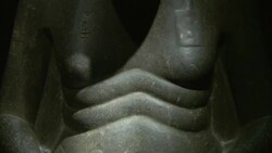 Light shines on the belly rolls of a statue of Amenhotep at Luxor Museum. Stock Footage