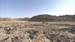 Dressed stones lie in a pile on the desert amid the ruins of an ancient structure. Stock Footage