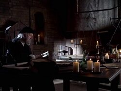 Nostradamus reads a book at his desk by candlelight. Stock Footage