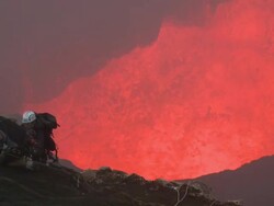 Climbers scale cliff dangerously close to erupting volcano, Marum Volcano, Ambrym Island, Vanuatu Stock Footage