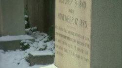 Snow covers the ground and a bottle of liquor leaning against Edgar Allan Poe's tombstone. Stock Footage