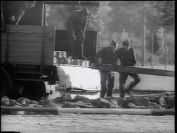 B/W 1961 soldiers removing wooden beam from truck for construction of Berlin Wall / Germany Stock Footage