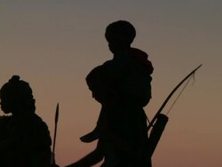 Silhouetted medium shot of bushman family walking Stock Footage