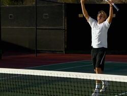 WS, PAN, MS, Two young men shaking hands above tennis net, Santa Barbara, California, USA Stock Footage