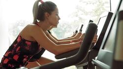 Women riding exercise bikes at gym Stock Footage