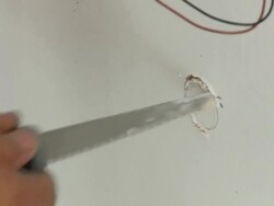 Electrician cuts circle in drywall Stock Footage