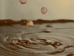 HD Super Slow-Mo: Hazelnuts In Chocolate Dip Stock Footage