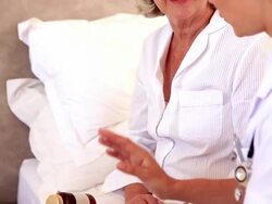 Home nurse speaking with elderly patient Stock Footage