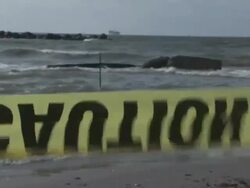 Workers cleaning up tarballs and oiled snare boom on Port Fourchon beaches, oil containment snare boom on beach to catch oil coming in, yellow 'caution' tape, truckload of absorbant boom / view of oil rigs off shore. Stock Footage