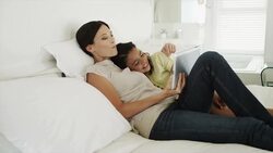 Mother and daughter on bed using digital tablet Stock Footage