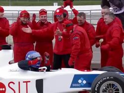 Medium shot pit crew cheering and celebrating as race car rolls into pit stop / zoom out driver hugging crew members Stock Footage