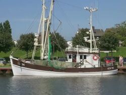 WS Shot of fishing cutter boats on harbor and house and cars parked, North Sea, North Frisia / Busum, Schleswig Holstein, Germany Stock Footage