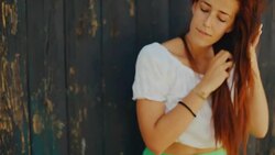Red haired girl makes braid to her hair Stock Footage