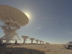 WS Truck pulling solar panel near satellites dishes on sunny day / San Augustine, New Mexico, USA  Stock Footage