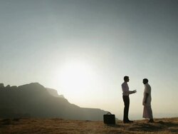 Businessman talking with a senior man on the cliff of mountain  Stock Footage
