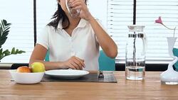 Woman eating apple at dining table Stock Footage