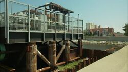Large pipes connect to a pumping station next to a canal. Stock Footage