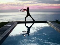 WS Male poi dancer performing in front of pool with reflection of his silhouette in pool at sunrise / Montezuma, Costa Rica Stock Footage