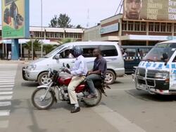 MS TS Shot of Two men on motorcycle crosses busy intersection / Kampala, Uganda Stock Footage