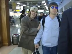 Liam Gallagher jokingly strokes brother Noel at Heathrow Stock Footage