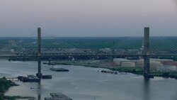 Cochrane-Africatown Bridge with barge and Mobile, Alabama buildings in background. Stock Footage