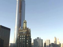 Low Angle pan-right zoom-out - A skyscraper towers over downtown Chicago, Illinois. / Chicago, Illinois, USA Stock Footage