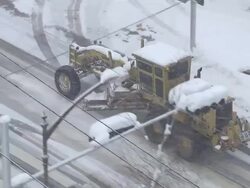 MS ZO ZI TS AERIAL Snowblower driving at street / Gangneung, Gangwon-do, South Korea Stock Footage