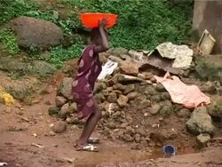 Young girl collecting water, Kroo Bay, Freetown, Sierra Leone Stock Footage