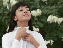  MS Portrait of young woman zipping up white jacket and smiling / Singapore Stock Footage