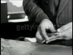 1947: U.S. NARCOTIC AGENTS: DRAMATIZATION: VS Dope peddler 'Nick Mazurki' at business stand w/ stooge, handing money to man in stand. CU Counting $100 bills. MS Undercover agent watching. MS Man nodding to stooge, stooge leaving. MS Agent following. Instructional Video