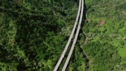 Aerial view of Hawaii's Interstate H-3, tilting up to Pearl Harbor in the distance. Stock Footage