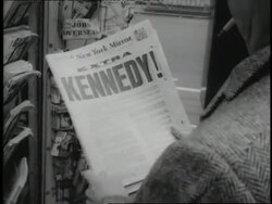 A man holds a newspaper bearing the headline, Kennedy! News Clip