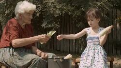 Little Girl Learns From Her Grandmother How to Peel off The Corn.. Real People, Rural Scene, User Generated Content. Stock Footage