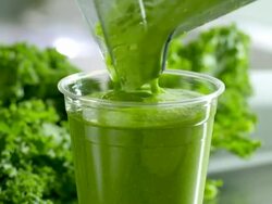ECU kale and spinach vegetable smoothie being poured from blender jar into clear plastic serving cup at organic juice bar Stock Footage