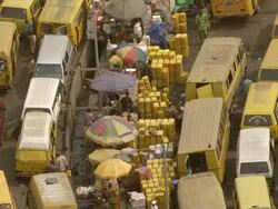 MS AERIAL DS Yellow cabs in streets market and Coloured umbrellas / Lagos, Nigeria Stock Footage