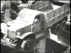 1940s: UNITED STATES NAVY PORT: VS U.S. Navy cargo ships, crane loading truck, soldiers carrying large bags, equipment, moving on ramp (gangplank) onto ship, male w/ clipboard, soldiers up stairs. WWII, World War II, Pacific Front, mobilizing Instructional Video