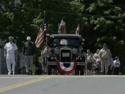 Parade in small town with antique car, flags, boy scounts, military, and marching band. Smalltown Americana. Stock Footage