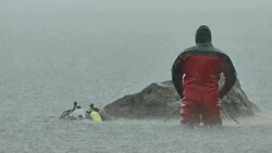 Marine police unit diving in lake with torential downpour Stock Footage