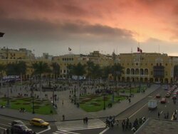 "View from top of building at corner of Plaza Mayor/Plaza de la Armas of Lima towards The Municipal Palace of Lima [Municipalidad Metropolitana de Lima] and the Palace of the Union , peach and orange sky, Lima, Peru" Stock Footage