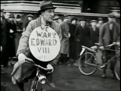 A man rides a bicycle while wearing a sign which proclaims We Want Edward VIII. News Clip
