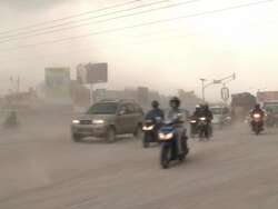 Traffic drives along road in Yogjakarta coated in volcanic ash after eruption of Merapi volcano; Central Java, Indonesia. 30 October 2010 / AUDIO Stock Footage