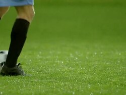 MS PAN TU professional soccer player dribbling ball on field in rain storm and passing ball to teammate Stock Footage