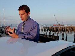 MS Man talking on bluetooth and typing on mobile phone while standing in sunroof opening of car / Portland, ME, United States Stock Footage