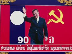 MS SLO MO Shot of large political poster with vehicles passing by / Vientiane, Laos Stock Footage