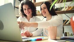 Two beautiful girls with laptop happy what they see on the screen Stock Footage