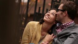 Hip young man kisses girlfriend as they gaze up at the autumn sky from the stoop of their brownstone apartment (dolly-shot) Stock Footage