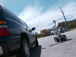 Medium Long Shot_static - A robot inspects a car as it slowly travels past. / Los Alamos, New Mexico, USA Stock Footage