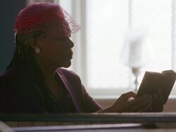MS PAN Senior woman sitting down in church pew and reading book near window / Port Gamble, Washington State, USA Stock Footage
