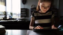 Schoolgirl using digital tablet in dark room Stock Footage